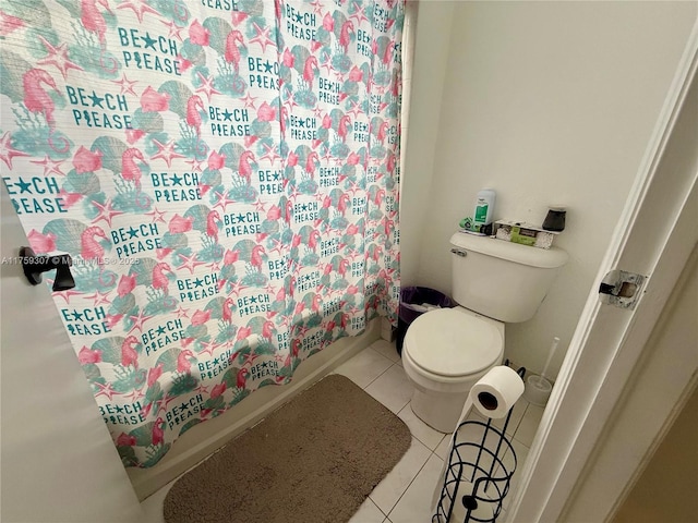 bathroom featuring a shower with shower curtain, toilet, and tile patterned floors