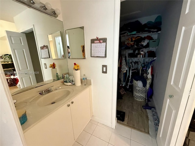 bathroom featuring a spacious closet, vanity, and tile patterned floors