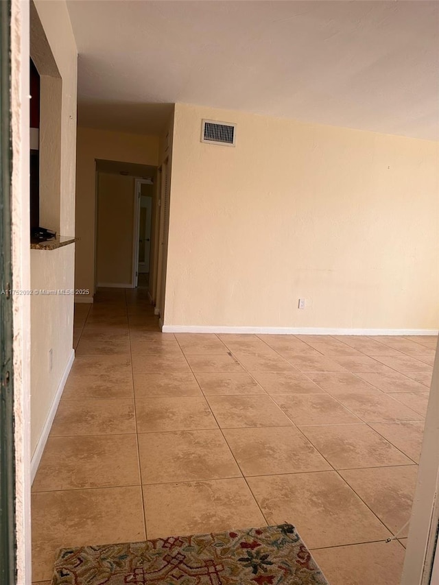 unfurnished room with light tile patterned floors, baseboards, and visible vents