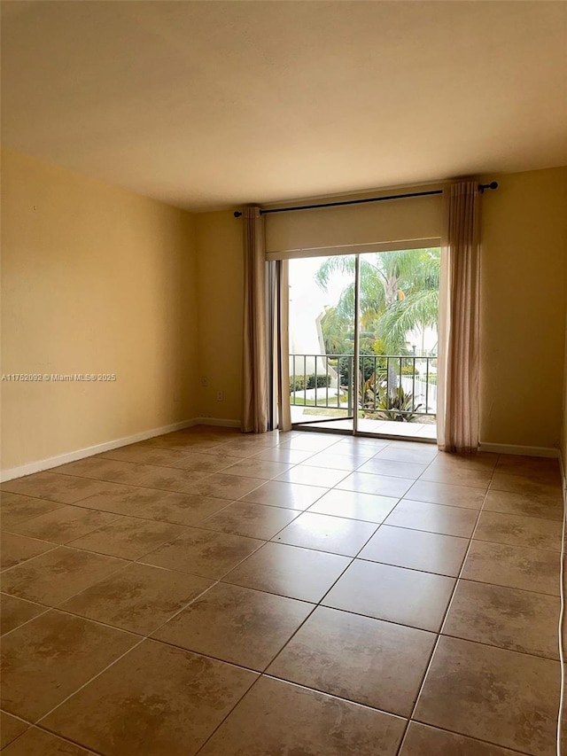 spare room with baseboards and tile patterned floors