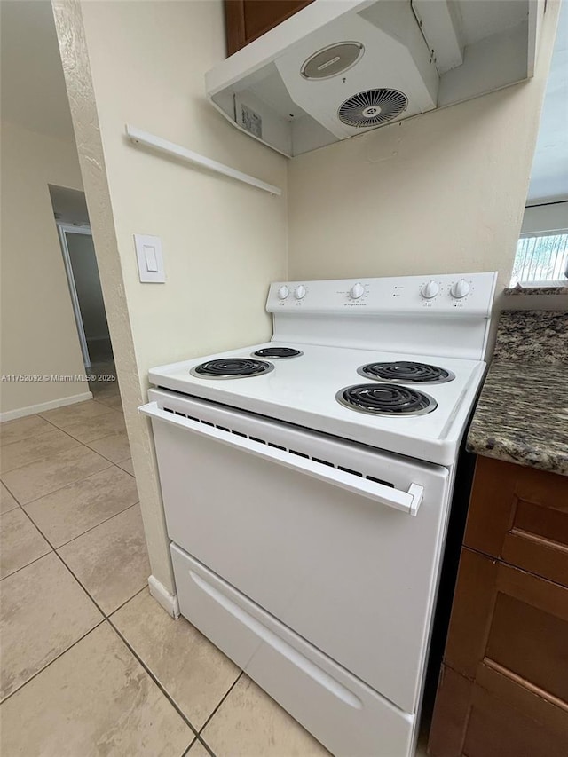 kitchen featuring baseboards, dark countertops, ventilation hood, white electric range, and light tile patterned flooring