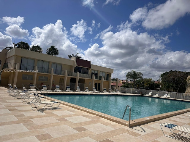 community pool featuring fence and a patio