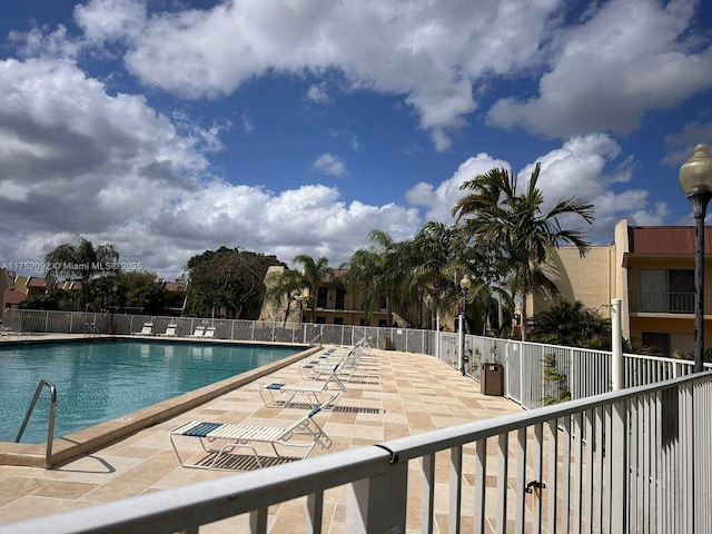 pool with fence and a patio