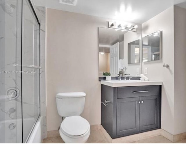 bathroom with toilet, shower / bath combination with glass door, baseboards, and vanity