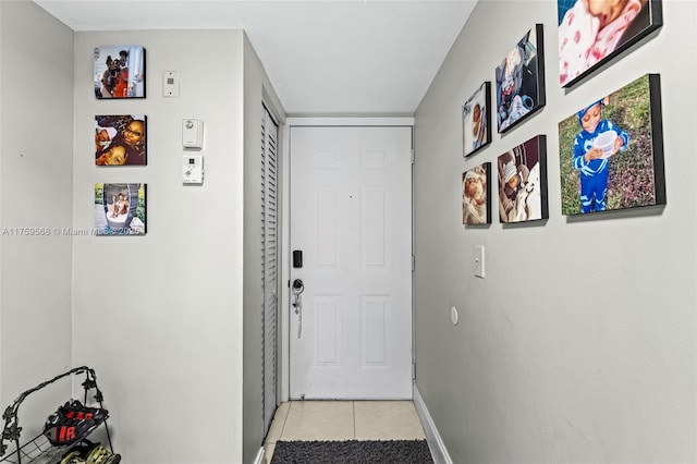 doorway featuring baseboards and light tile patterned floors