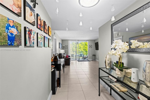 hallway featuring tile patterned flooring and baseboards