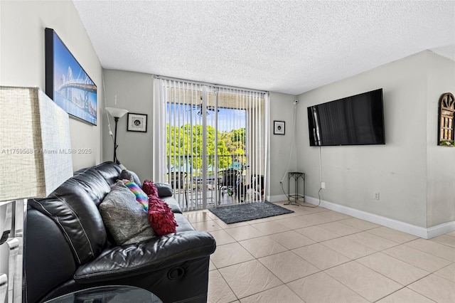 living area with a textured ceiling, baseboards, and light tile patterned floors