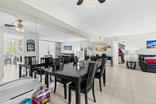 dining room with light tile patterned floors, a textured ceiling, visible vents, a ceiling fan, and baseboards