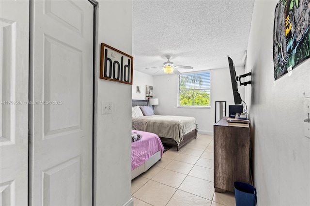 bedroom featuring a textured ceiling, ceiling fan, and light tile patterned flooring