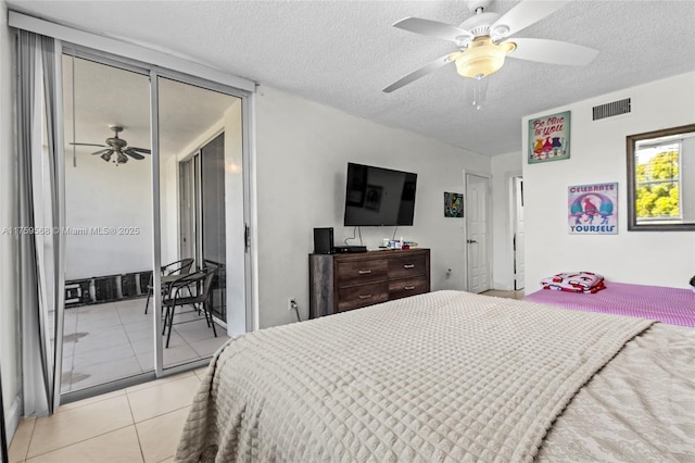 bedroom featuring a ceiling fan, visible vents, a textured ceiling, and light tile patterned flooring