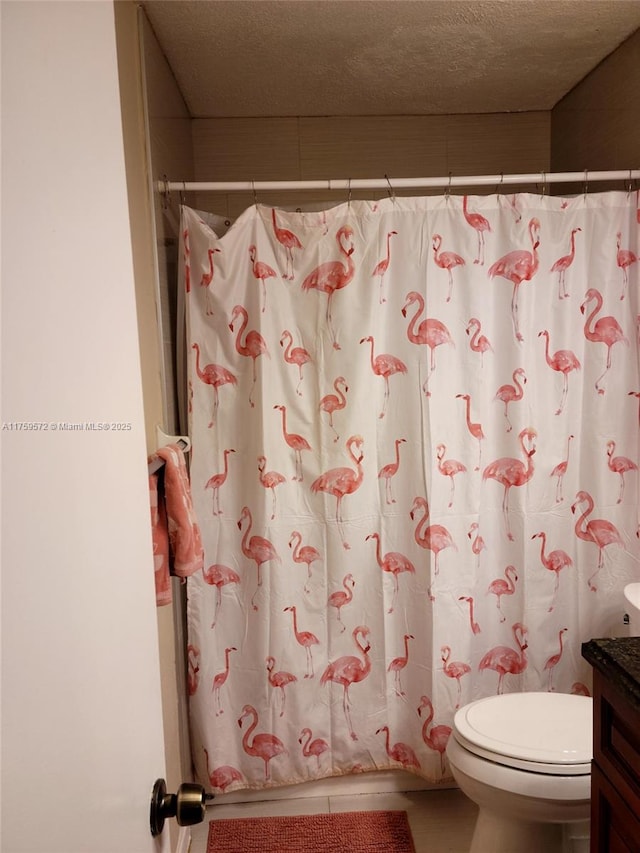 full bathroom featuring tile patterned flooring, toilet, vanity, and a textured ceiling