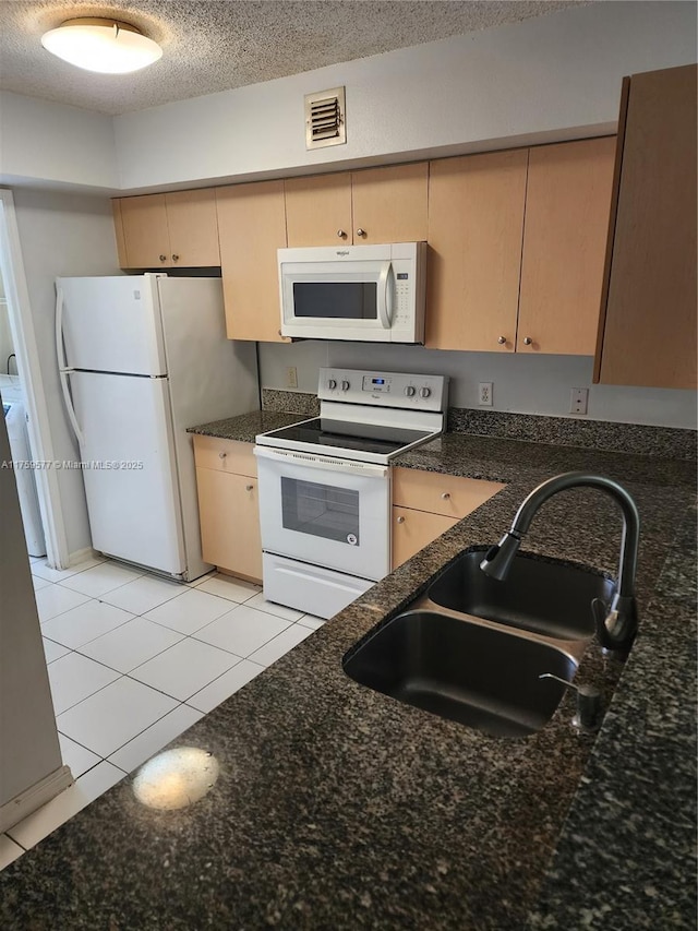 kitchen with visible vents, light tile patterned flooring, white appliances, a textured ceiling, and a sink