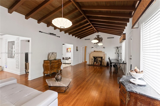 living room with wood ceiling, a fireplace, beam ceiling, and wood finished floors