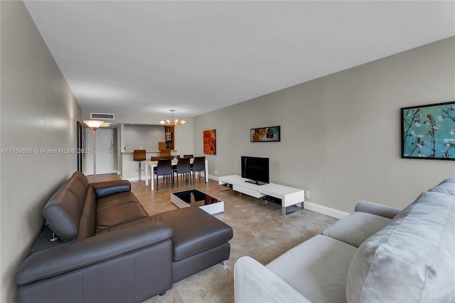 living area featuring visible vents, a notable chandelier, and baseboards