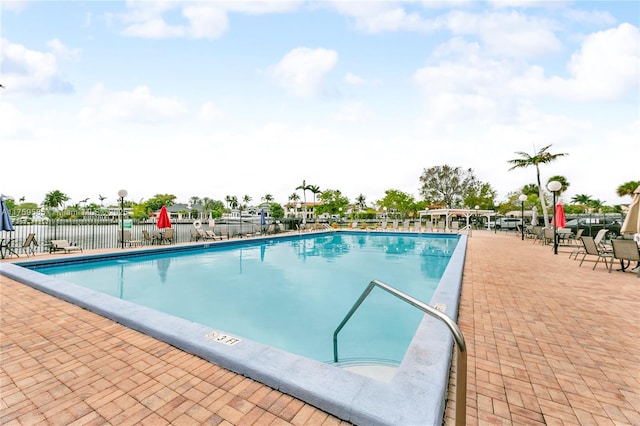 pool with a patio and fence