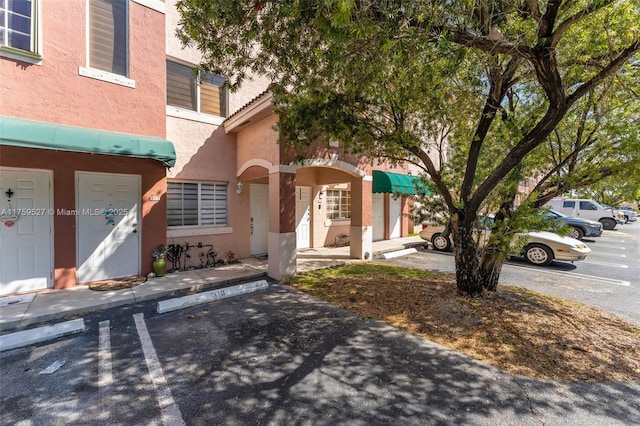 exterior space with uncovered parking and stucco siding