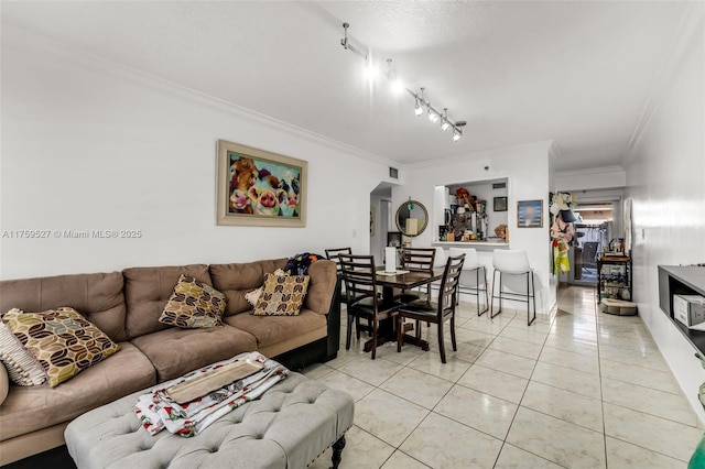 living area with light tile patterned floors, crown molding, and rail lighting