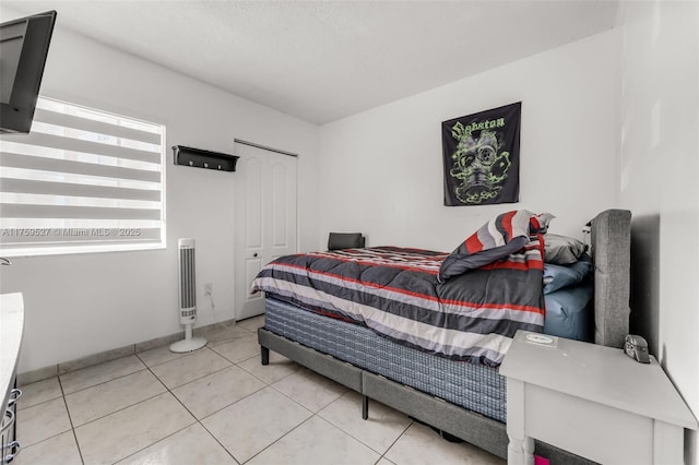 tiled bedroom with a closet