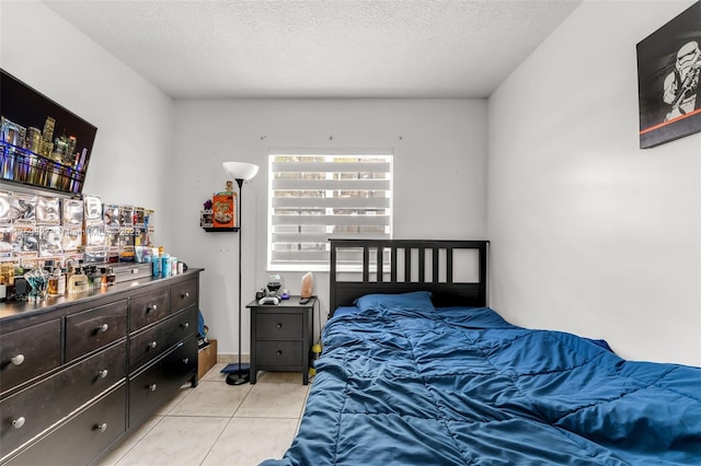 bedroom with light tile patterned floors and a textured ceiling