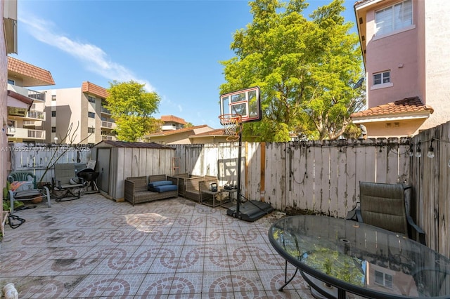 view of patio / terrace with a shed, a grill, a fenced backyard, and an outdoor structure