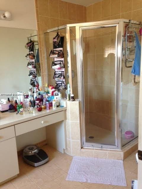 full bathroom featuring a stall shower, vanity, and tile patterned floors