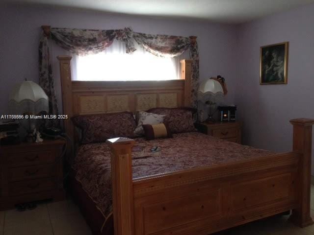 bedroom featuring multiple windows and light tile patterned flooring