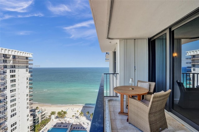 balcony with a water view and a view of the beach