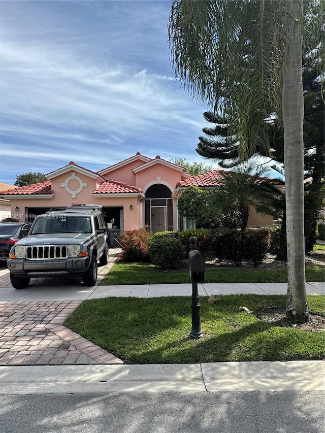 view of front of house with a tiled roof, a front lawn, decorative driveway, and stucco siding