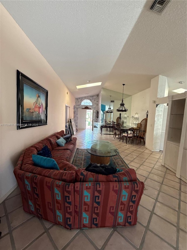 living area with vaulted ceiling, a textured ceiling, and visible vents