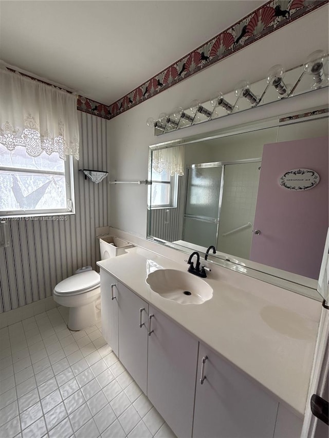 bathroom with toilet, a shower with shower door, tile patterned flooring, and vanity