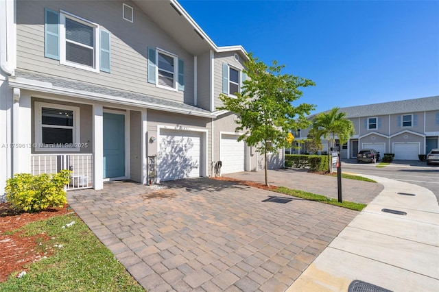 multi unit property featuring a garage and driveway