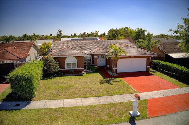 mediterranean / spanish home featuring an attached garage, stucco siding, a front lawn, and a tiled roof