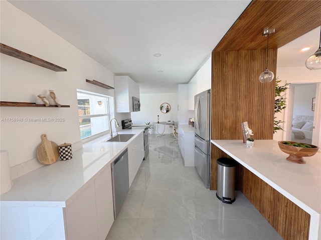 kitchen with light countertops, white cabinets, stainless steel appliances, modern cabinets, and a sink