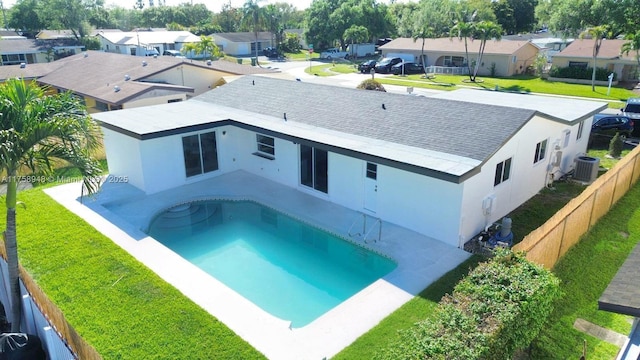 back of property with a yard, cooling unit, a residential view, and stucco siding