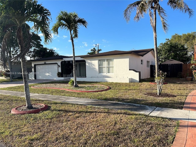 ranch-style house with stucco siding, a front yard, fence, a garage, and driveway