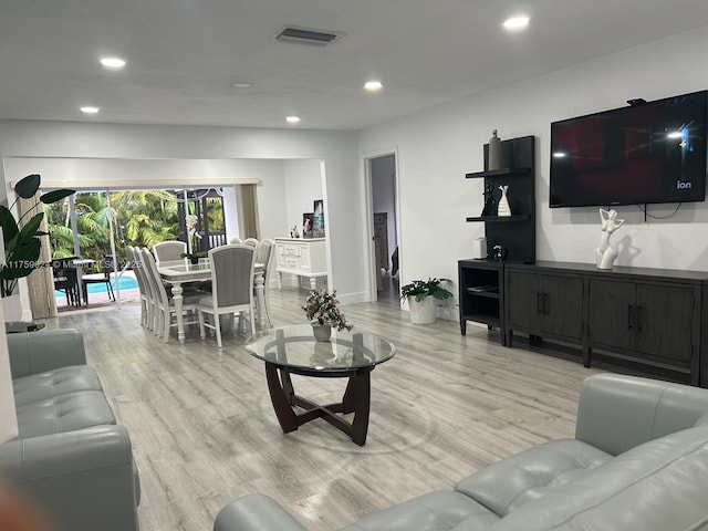 living room with baseboards, light wood finished floors, visible vents, and recessed lighting