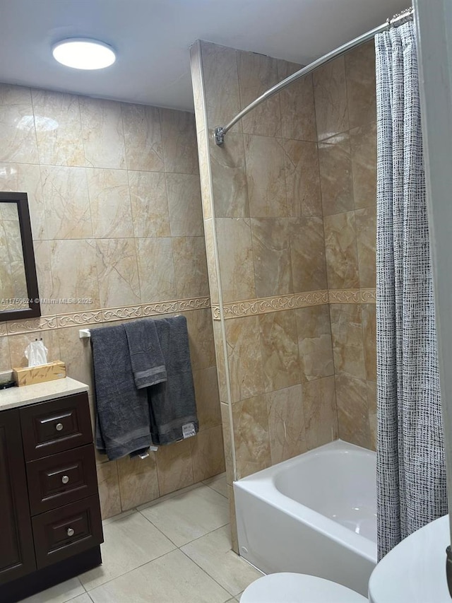 full bath featuring toilet, shower / tub combo, vanity, tile walls, and tile patterned floors