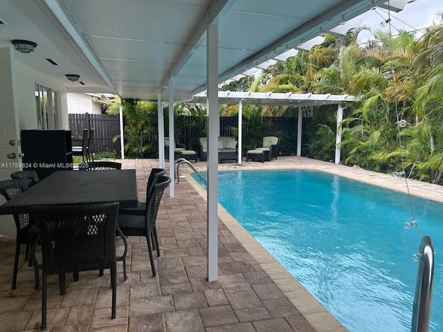 view of swimming pool with fence, outdoor dining area, a fenced in pool, and a patio