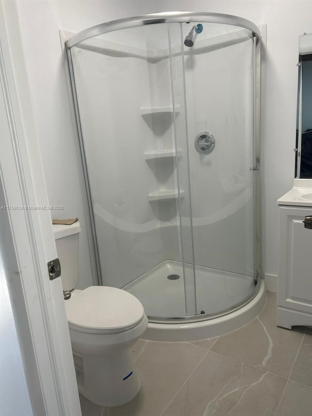 bathroom with toilet, a shower stall, and vanity