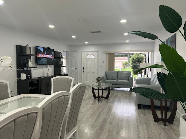 living room with light wood finished floors, visible vents, and recessed lighting