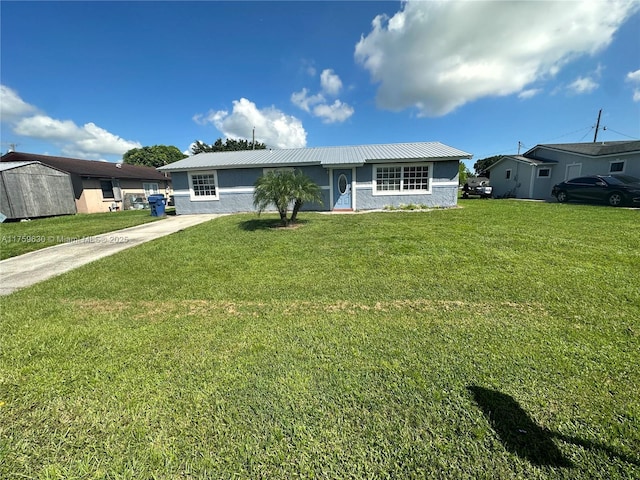 single story home featuring stucco siding, driveway, metal roof, and a front lawn