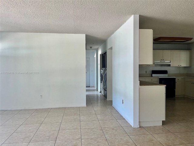 kitchen featuring under cabinet range hood, light tile patterned floors, range with electric cooktop, and a textured ceiling