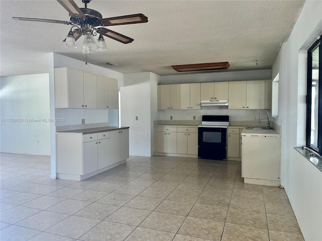 kitchen featuring black electric range oven, a textured ceiling, under cabinet range hood, a sink, and light tile patterned flooring