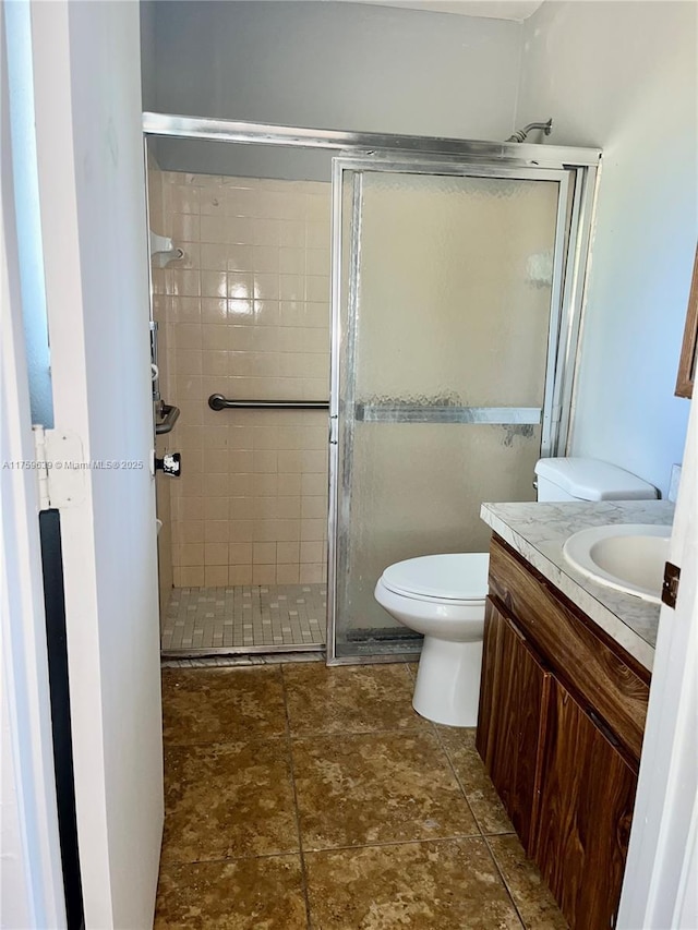 full bathroom with toilet, a shower stall, and vanity