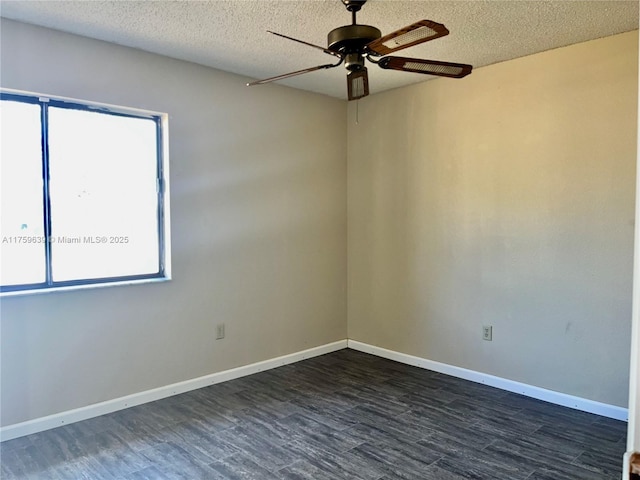 spare room with a ceiling fan, a textured ceiling, baseboards, and dark wood-type flooring