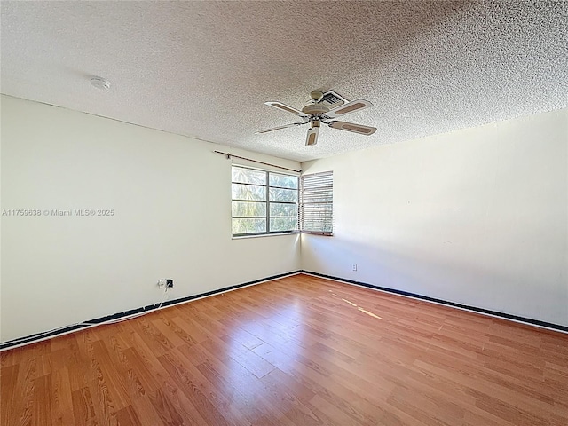 unfurnished room with ceiling fan, a textured ceiling, and wood finished floors