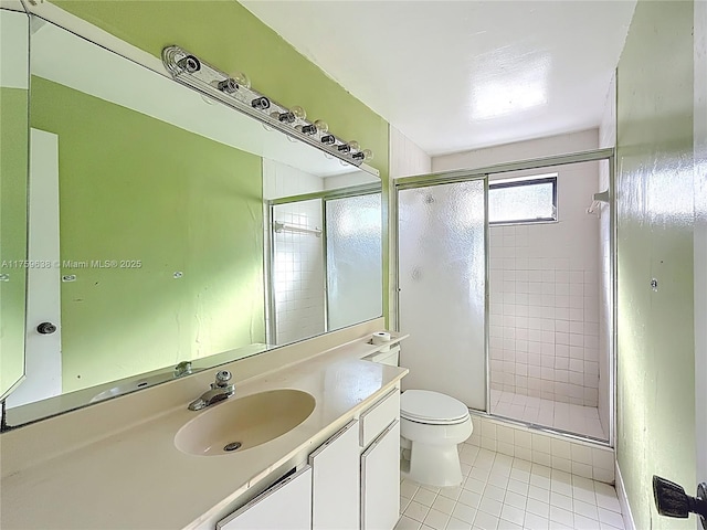 bathroom featuring vanity, toilet, a shower stall, and tile patterned flooring