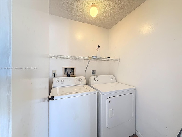 laundry area featuring separate washer and dryer, laundry area, and a textured ceiling