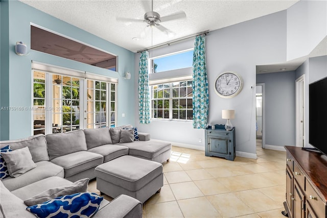 living room featuring french doors, light tile patterned floors, ceiling fan, a textured ceiling, and baseboards