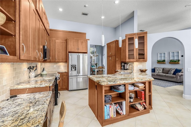 kitchen featuring open shelves, brown cabinetry, stainless steel appliances, and a sink